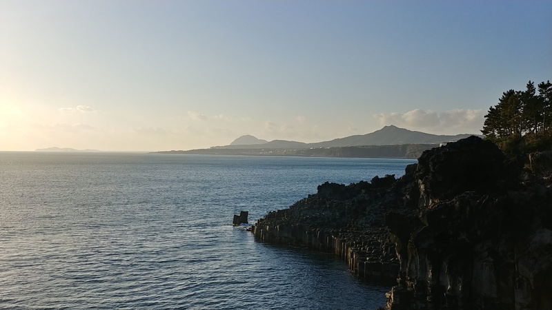 jeju island, travel, outdoors, sky, tranquility, scenics - nature, water, non-urban scene, tranquil scene, copy space, waterfront, mountain, rock, rock - object