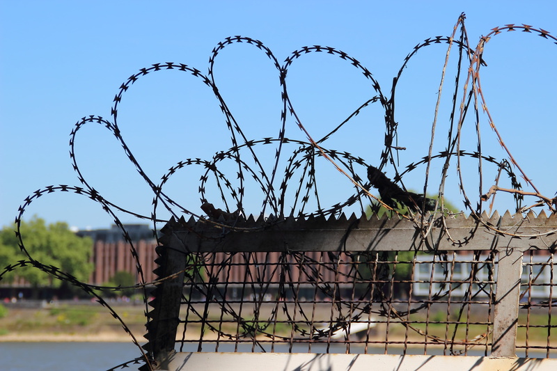 warning sign, metal, sky, low angle view, architecture, no people, Fence, sharp, built structure, Freedom, barrier, border, Barbed Wire, forbidden, chainlink Fence