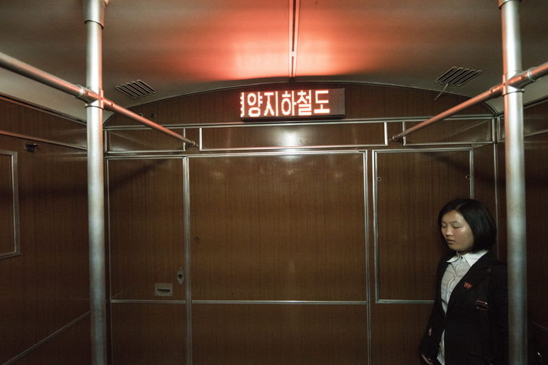 western script, human, leaving, illuminated, building, business, electronics, sign, near, suit, metro, wooden, brown, entrance, communication, adult, coat