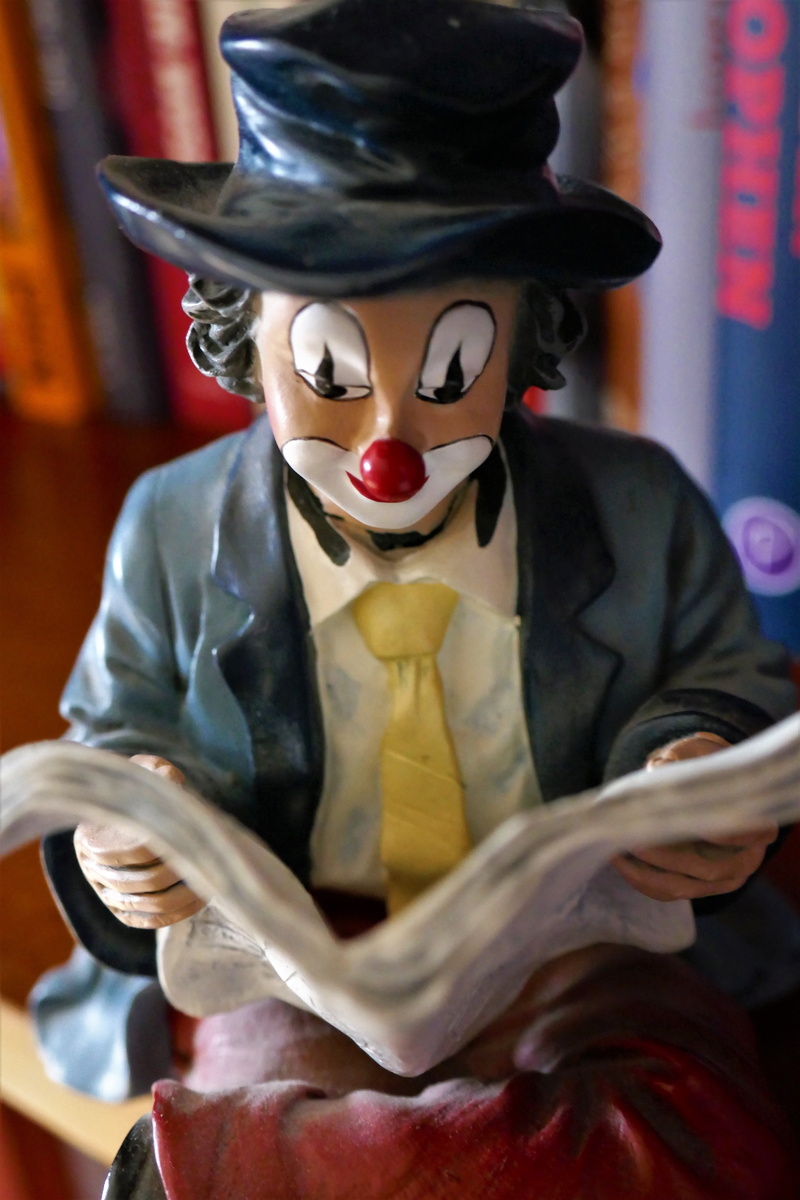 curious, books, obscured face, newspaper, clothing, holding, read, indoors, disguise, figure, clown nose, 5K, news, make-up, paint, sculpture, sit, art and craft