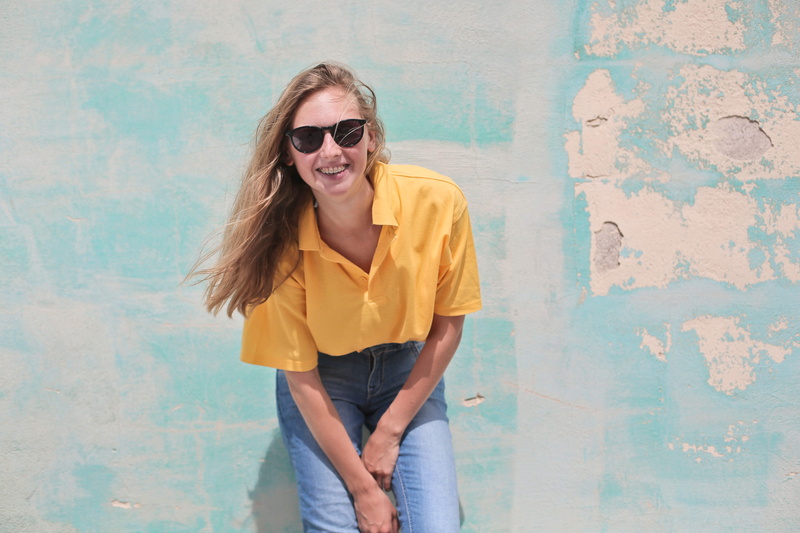 jeans, fashion, wall, wearing, blue denim, shades, women, yellow shirt, happiness, yellow, indoors, happy, blue jeans, glasses, shirt, young, yellow polo shirt