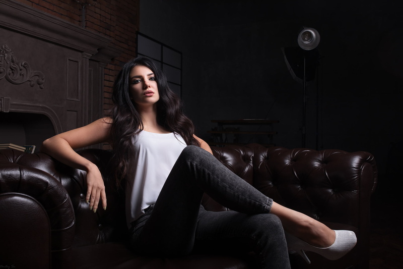 blue eyes, front view, beauty, seat, chair, brunette, contemplation, curly hair, women, leather, sitting, long hair, looking at viewer, lifestyles, fashion