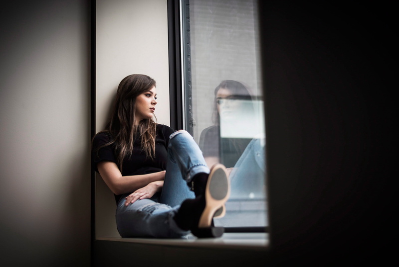 contemplation, celebrities, looking, hailee steinfeld, casual clothing, one person, three quarter length, women, day dreaming, real people, window, indoors