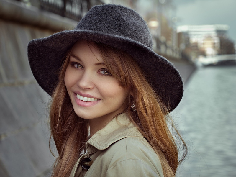 portrait, clothing, hairstyle, brown hair, teeth, trench coat, hair, millinery, long hair, smiling, model, headshot, emotion, warm clothing, young adult