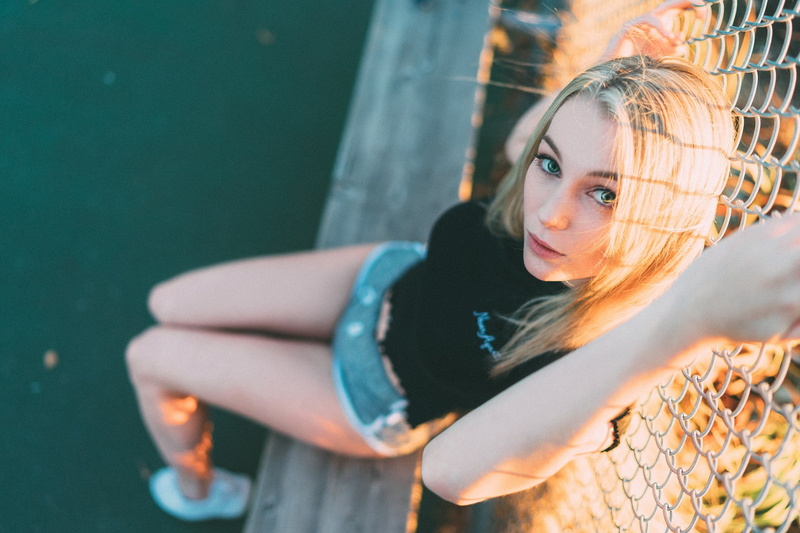 depth of field, 1080P, women, women outdoors, shorts, sitting, STPeach, fence, blonde, looking at viewer, model, green eyes