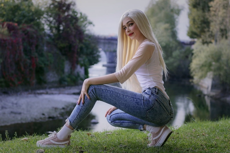 women outdoors, water, socks, purple nails, sneakers, jeans, long nails, looking at viewer, red lipstick, eyelashes, river, makeup, long hair, grass, dyed hair