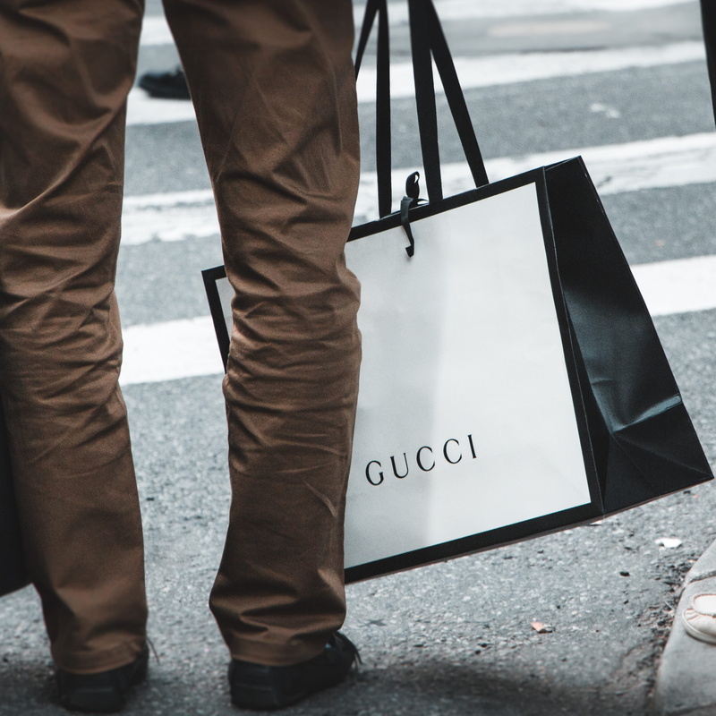near, socks, male, sign, street, shopping, bag, day, body part, outdoors, western script, person, holding, human leg, human foot, shoe, 2K, jeans, human body part