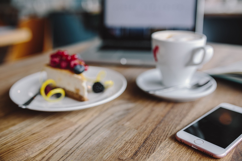 tech, food, portable information device, connection, cup, food and drink, wooden desk, communication, business, mobile, cheese cake, desk, coffee, workspace