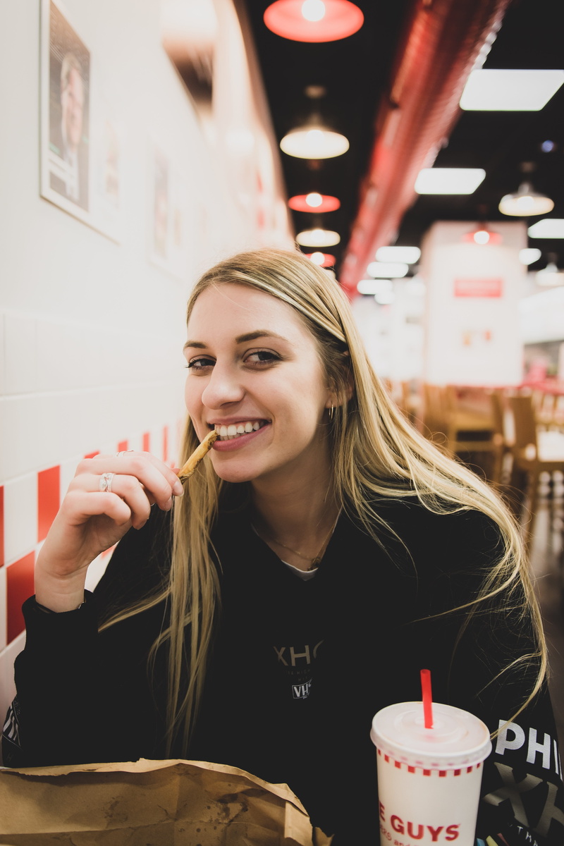 food and drink, leisure activity, food court, human, restaurant, candle, food, blond hair, one person, hairstyle, dating, eating, women, portrait, teeth