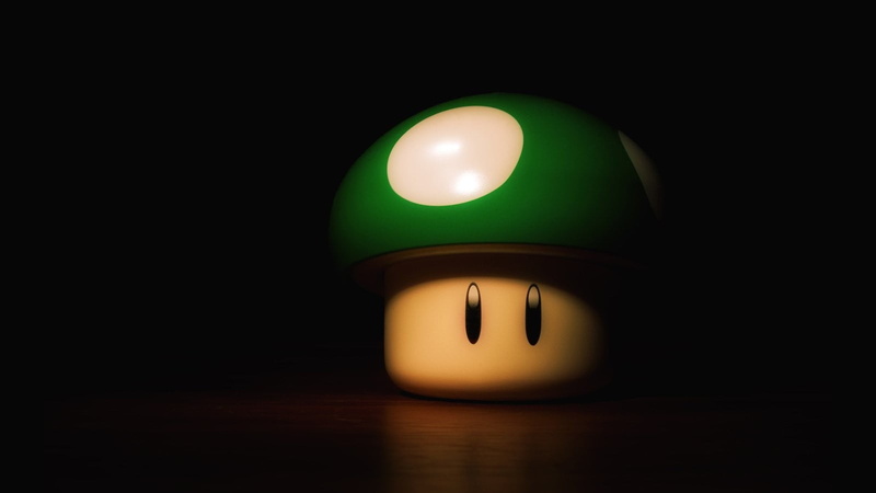 Super Mario, headwear, table, copy space, electric lamp, black background, studio shot, green color, indoors, light - natural phenomenon, cut out, illuminated