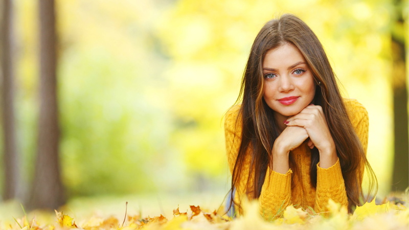 looking at viewer, leaves, sweater, brunette, women outdoors, yellow sweater, women, portrait, model, trees, fall, smiling, lying on front, nature, face