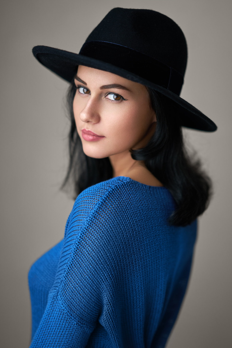 hairstyle, hat, waist up, indoors, colored background, Soňa Machyňáková, beautiful woman, one person, hair, black hair, portrait, clothing, looking at camera
