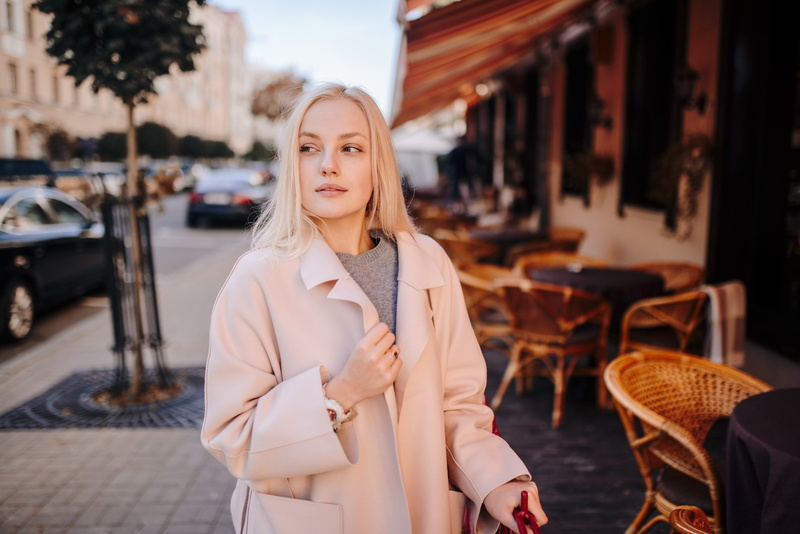 looking away, city, young adult, leisure activity, straight hair, waist up, 2K, blonde, women outdoors, beauty, white coat, looking at camera, portrait