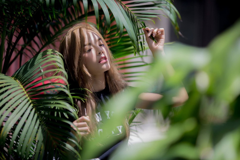 lifestyles, leisure activity, green color, beautiful woman, plant, outdoors, brown hair, real people, headshot, front view, portrait, Noree Key Wijitra