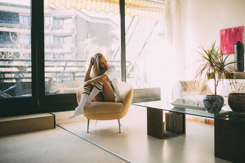 legs crossed, hairstyle, indoors, home interior, long hair, day, blond hair, flooring, seat, couch, lifestyles, contemplation, 1080P, blonde, hair, one person