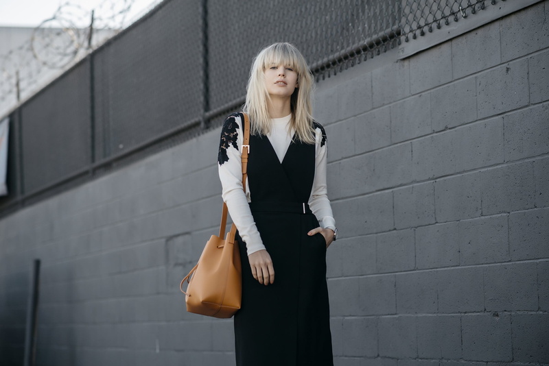 architecture, real people, built structure, blonde, dress, hands in pockets, bag, clothing, standing, building exterior, leather, 1080P, young adult, beautiful woman