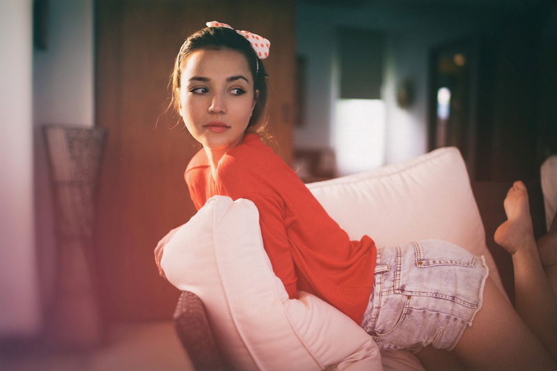 couch, brown eyes, 1080P, hair ribbon, red clothing, sitting, kneeling, Paul Toma, women, jean shorts, brunette