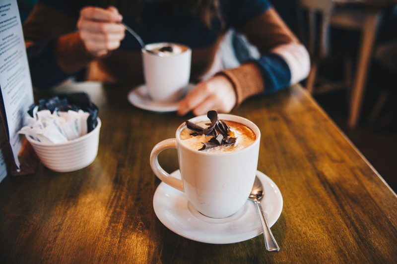 coffee cup, restaurant, 4K, cream, table, eating utensil, kitchen utensil, wood - material, food and drink, chocolate, human hand, mug, hot chocolate