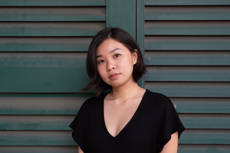 looking at camera, beauty, stands, wall, neckline, clothing, one person, hairstyle, casual clothing, painted, headshot, contemplation, dress, home decor