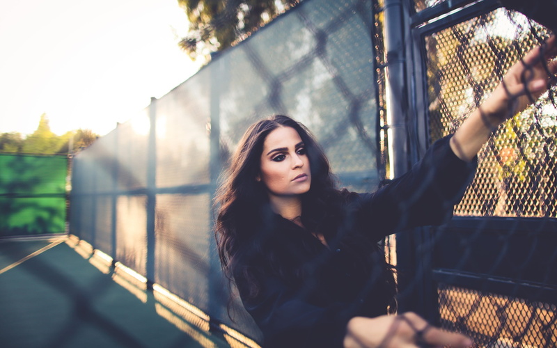 day, 2K, nature, barrier, portrait, one person, top, chain-link, front view, hair, contemplation, hairstyle, sleeved, neck, bokeh, brunette, elbow, v