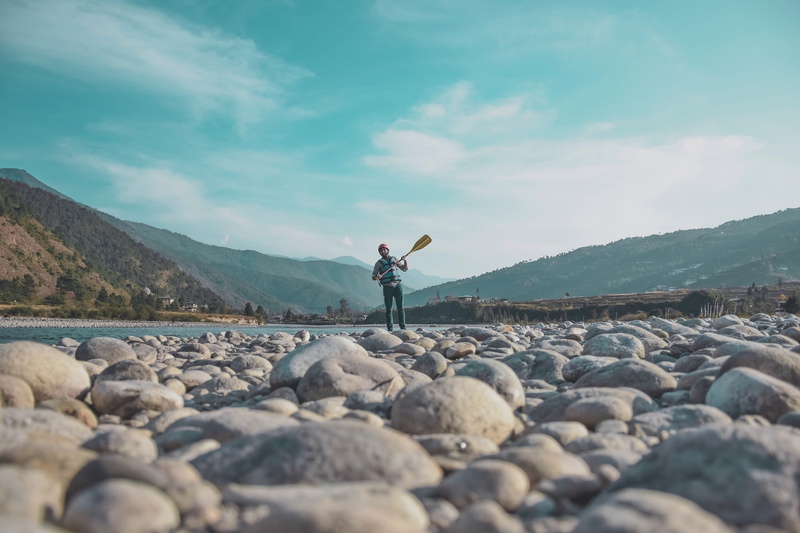 oar, bhutan landscape, landscape, solid, rock, hill, standing, leisure activity, holding, human arm, rafting, real people, 5K, mountain, daytime, helmet