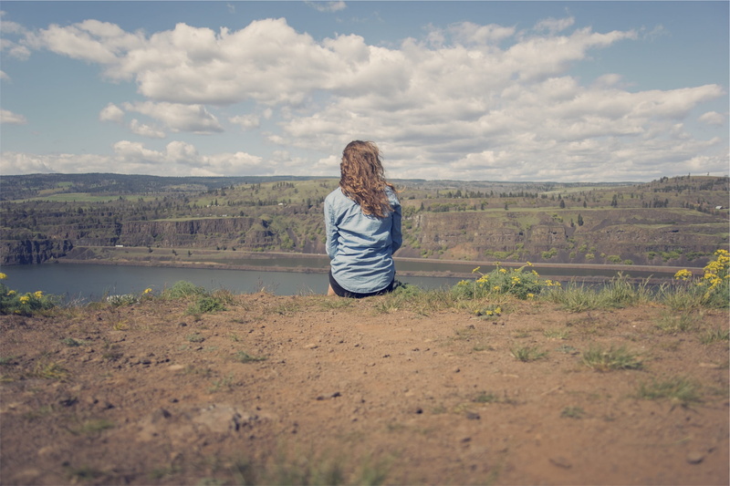 fields, tranquility, sitting, blue, beauty in nature, casual clothing, cliff, hairstyle, stratus clouds, cloud - sky, brunette, denim, clouds, stratus