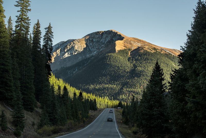 pavement, sky, light, gray, vehicle, forest, road marking, beauty in nature, nature, symbol, day, concrete, trees, mountain, scenics - nature, taken, sunshine