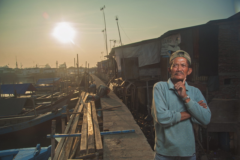 landscape, port, sea, portrait, standing, looking at camera, long, walkway, harbor, sun, ships, gray, houses, boats, dock, fisherman, sunset, near, man
