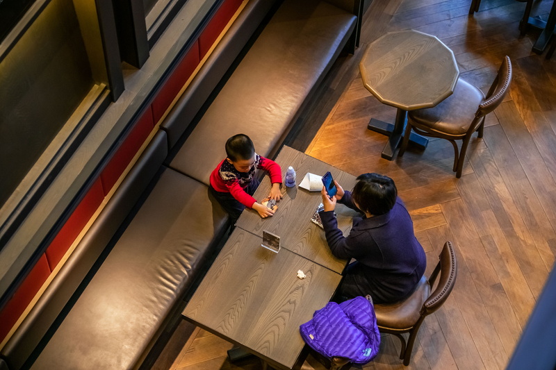 4K, sitting, electronics, plywood, real people, cafeteria, apparel, casual clothing, human, full length, wood - material, adult, desk, women, technology