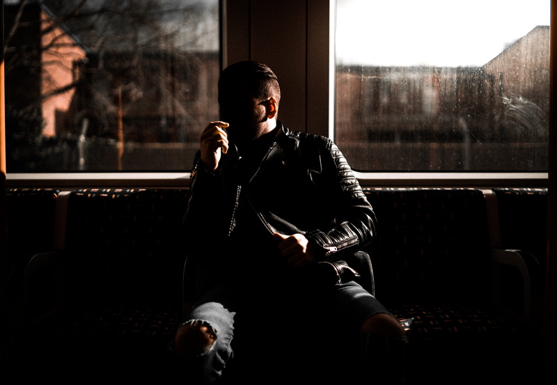 coat, clothing, bar counter, men, young adult, furniture, front view, human, leaning, 5K, sitting, mid adult, adult, wall, one person, window, leather