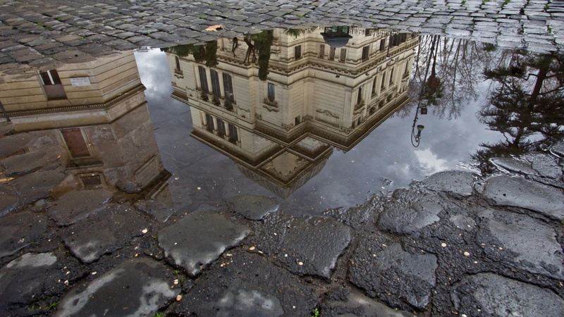 stones, no people, wet, reflection, outdoors, street, standing water, trees, building, brown, clouds, building exterior, water, built structure, nature