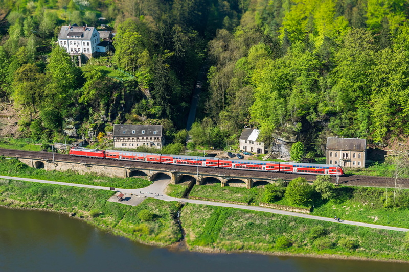 public transportation, outdoors, architecture, no people, near, green color, railroad track, miniature, mode of transportation, day, red, transportation