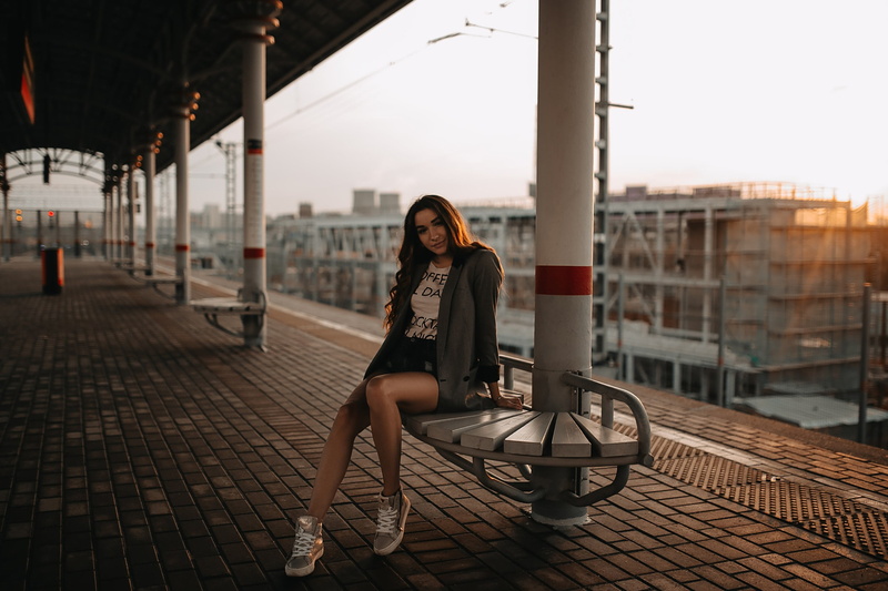 full length, beautiful woman, transportation, portrait, one person, train station, jean shorts, real people, adult, sneakers, outdoors, hairstyle, front view