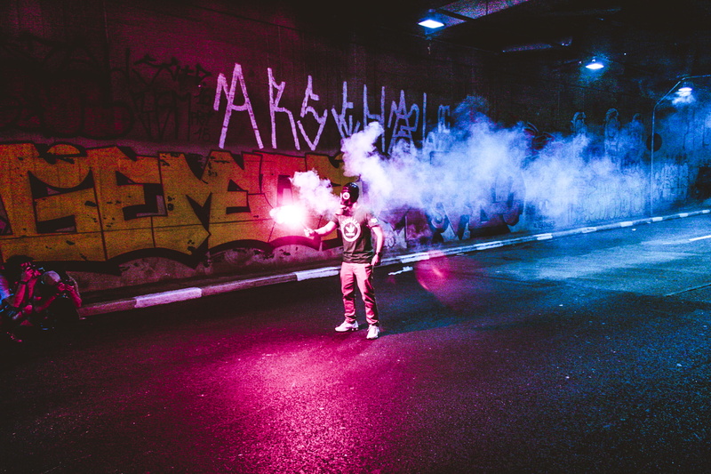 road, smoke, real people, stage - performance space, one person, full length, neon, sparkler, man, lifestyles, women, person, lights, architecture, holding