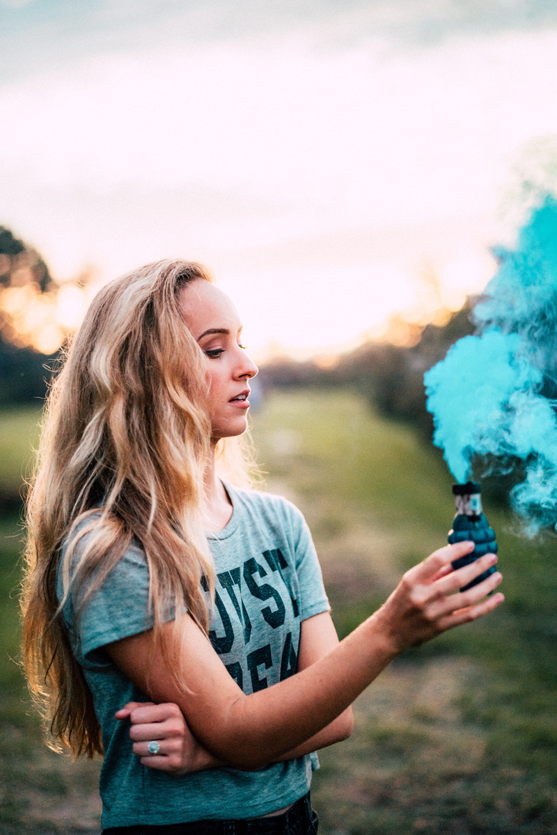 w, female, smoke, day, side view, young adult, lifestyles, women, holding, standing, hand, outdoors, bombs, casual clothing, waist up, blond hair, caucasian