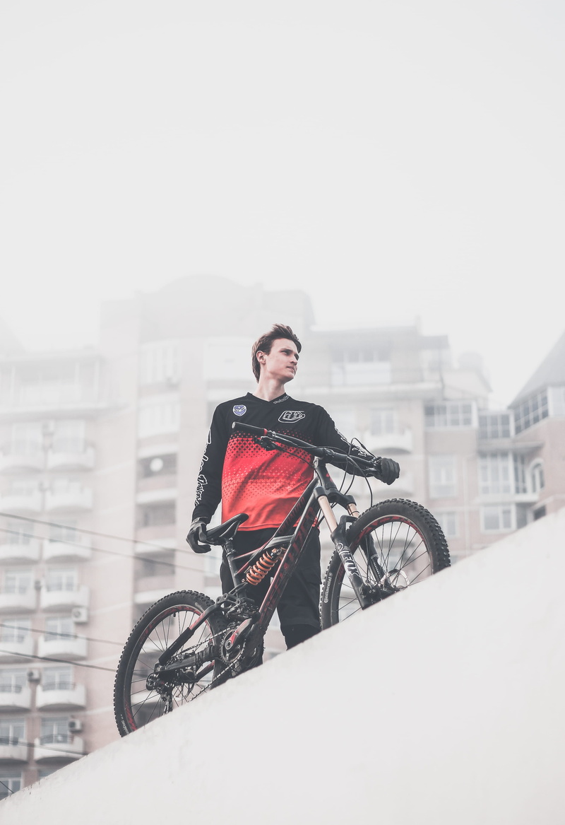 biker, bmx, platform, suspension, person, full, cold temperature, wearing, holding, shirt, city, land vehicle, red, downhill, day, black, architecture