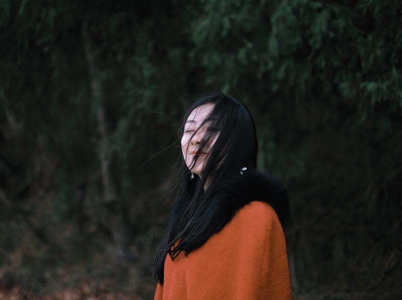 adult, real people, near, fur, young adult, focus on foreground, black hair, hairstyle, standing, portrait, woman, hair, female, trees, smiling, leisure activity