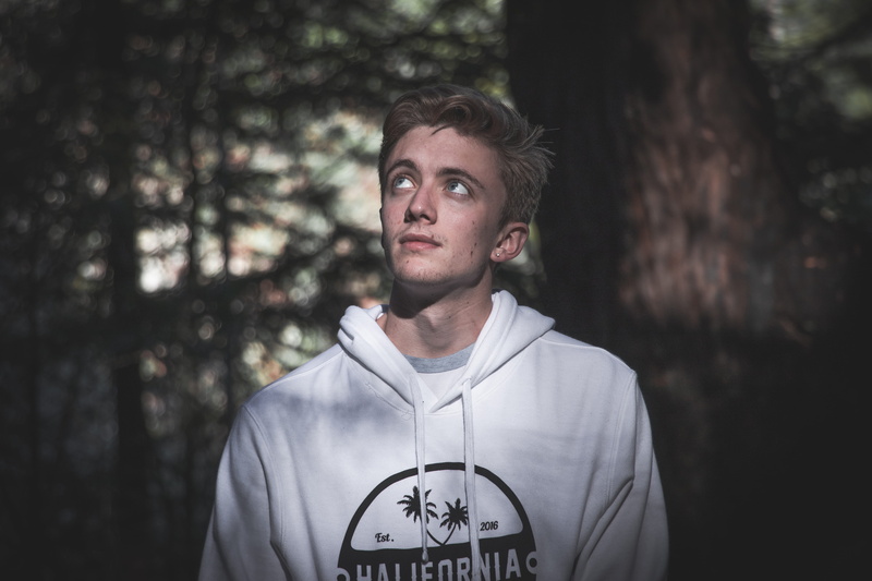front view, 5K, blond hair, man, wear, young men, standing, lifestyles, person, near, leisure activity, boy, focus on foreground, facial expression, plant