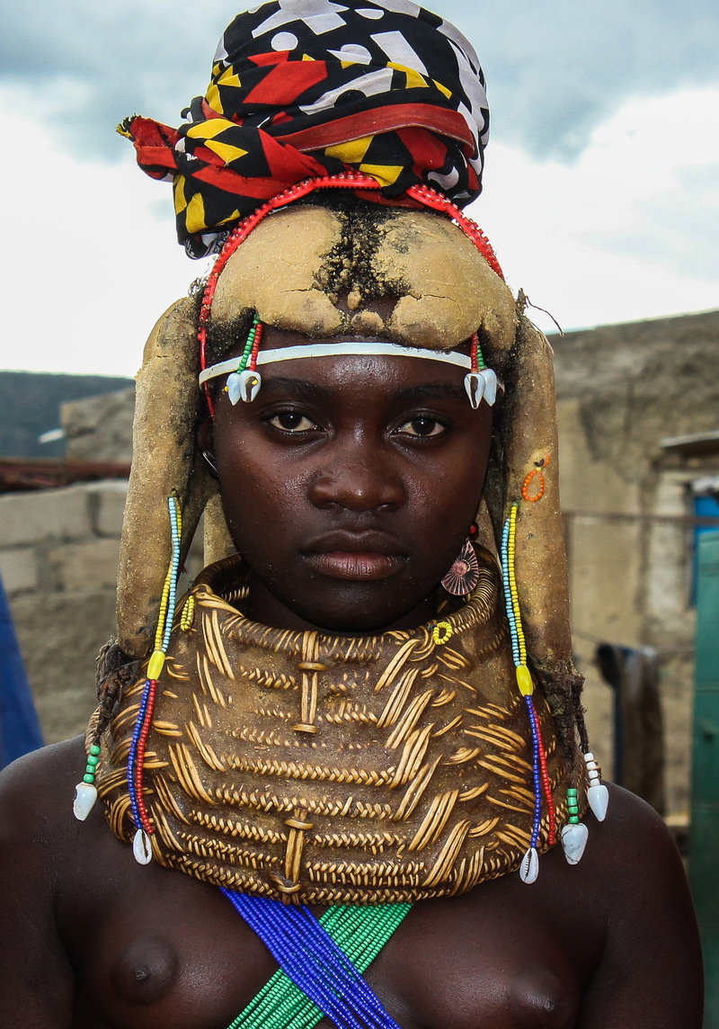 portrait, focus on foreground, turban, africa, front view, clothing, mumuila, 2K, close-up, sky, brown, jewelry, black, near, one person, standing, lifestyles