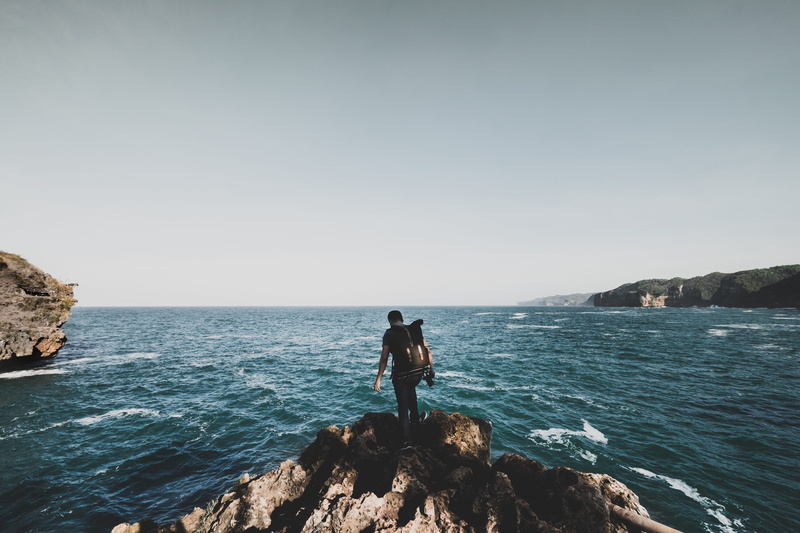 jogja, leisure activity, male, cliff, wave, lifestyles, landscape, nature, beauty in nature, looking at view, full length, coast, horizon over water, grey