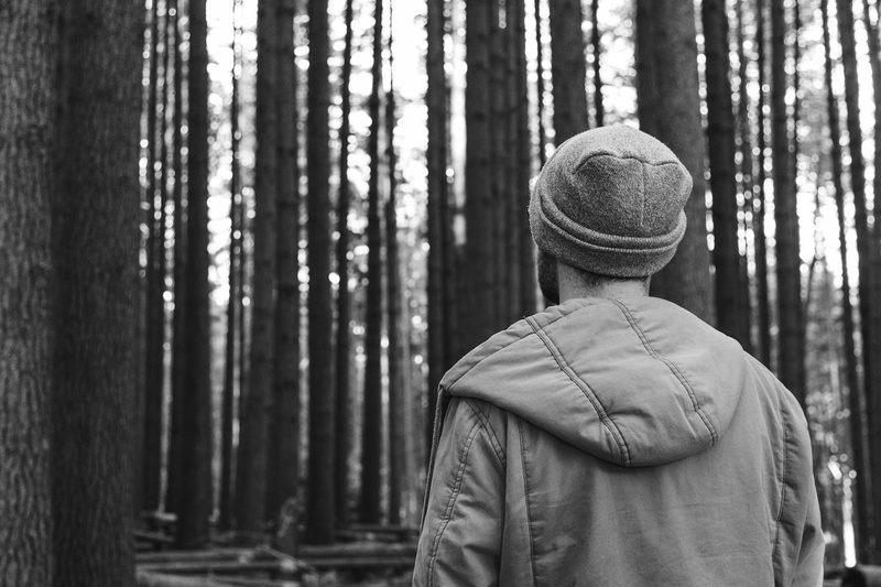 nature, focus on foreground, parka, warm clothing, day, lifestyles, forest, waist up, land, trees, grayscale, portrait, black and white, standing, man