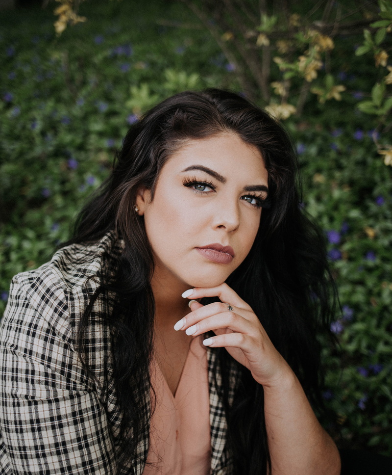 young adult, black hair, apparel, looking at camera, contemplation, headshot, blue bells, brown hair, one person, front view, female, clothing, finger