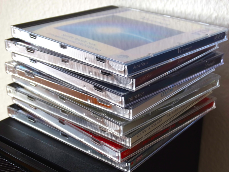 music cd, focus on foreground, cd cover, 5K, drawer, high angle view, design, still life, container, day, plastic, table, music, publication, education