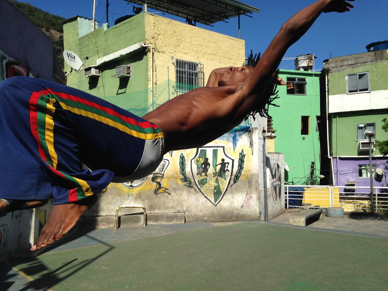 real people, building exterior, human arm, hand, lifestyles, one person, capoeira, man, favela, art and craft, flip, brazil, body part, sunlight, performance