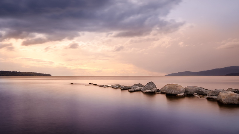 sunset, tranquil scene, water, horizon over water, reflection, lagoon, environment, tranquility, sea, body, sky, landscape, rock - object, solid, stones
