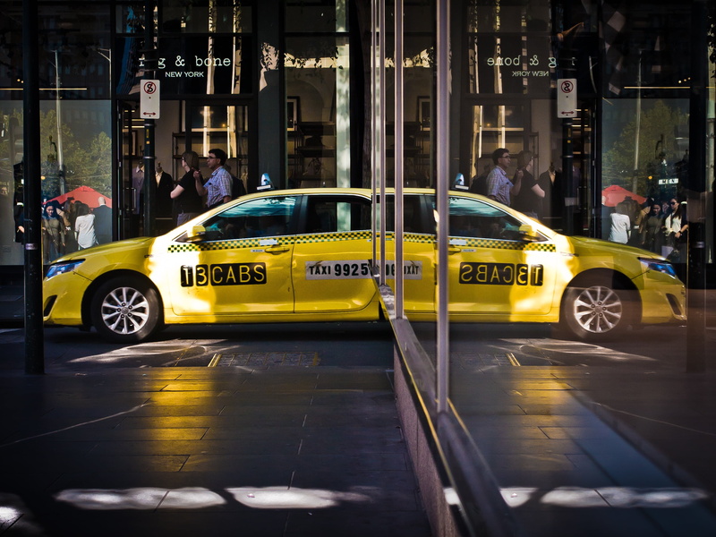 land vehicle, architecture, real people, motion, reflection, street, mirror, built structure, yellow Taxi, building exterior, taxi, yellow, people, mode of Transport