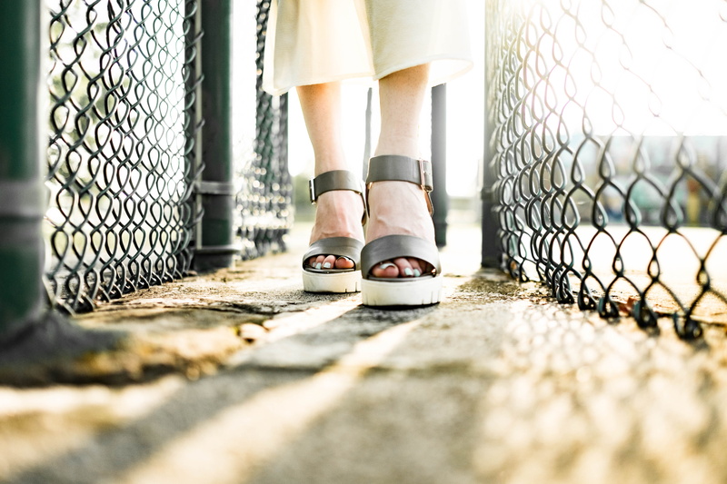 human leg, sandals, fences, one person, human limb, woman, low section, fence, shoe, human foot, women, outdoors, adult, feet, shadow, focus on background