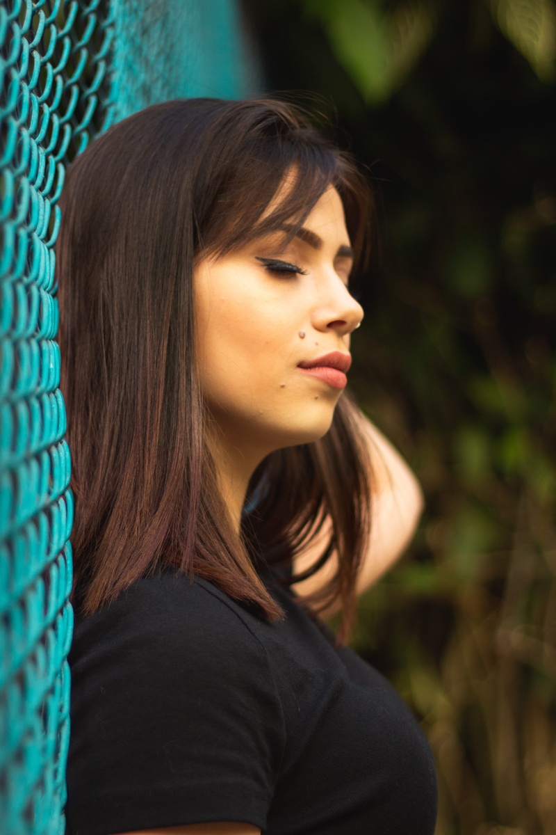 one person, contemplation, fence, women, teenager, lifestyles, casual clothing, real people, pretty, close-up, brunette, focus on foreground, brown hair