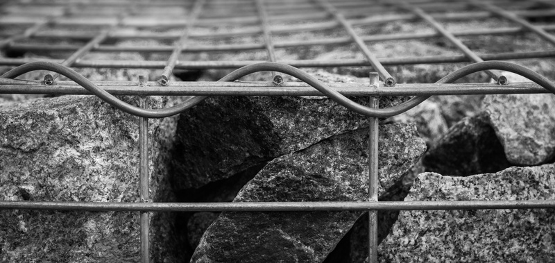 iron - metal, solid, rock, city, transportation, rod, black and white, iron, fence, built structure, no people, barrier, steel, grating, outside, building