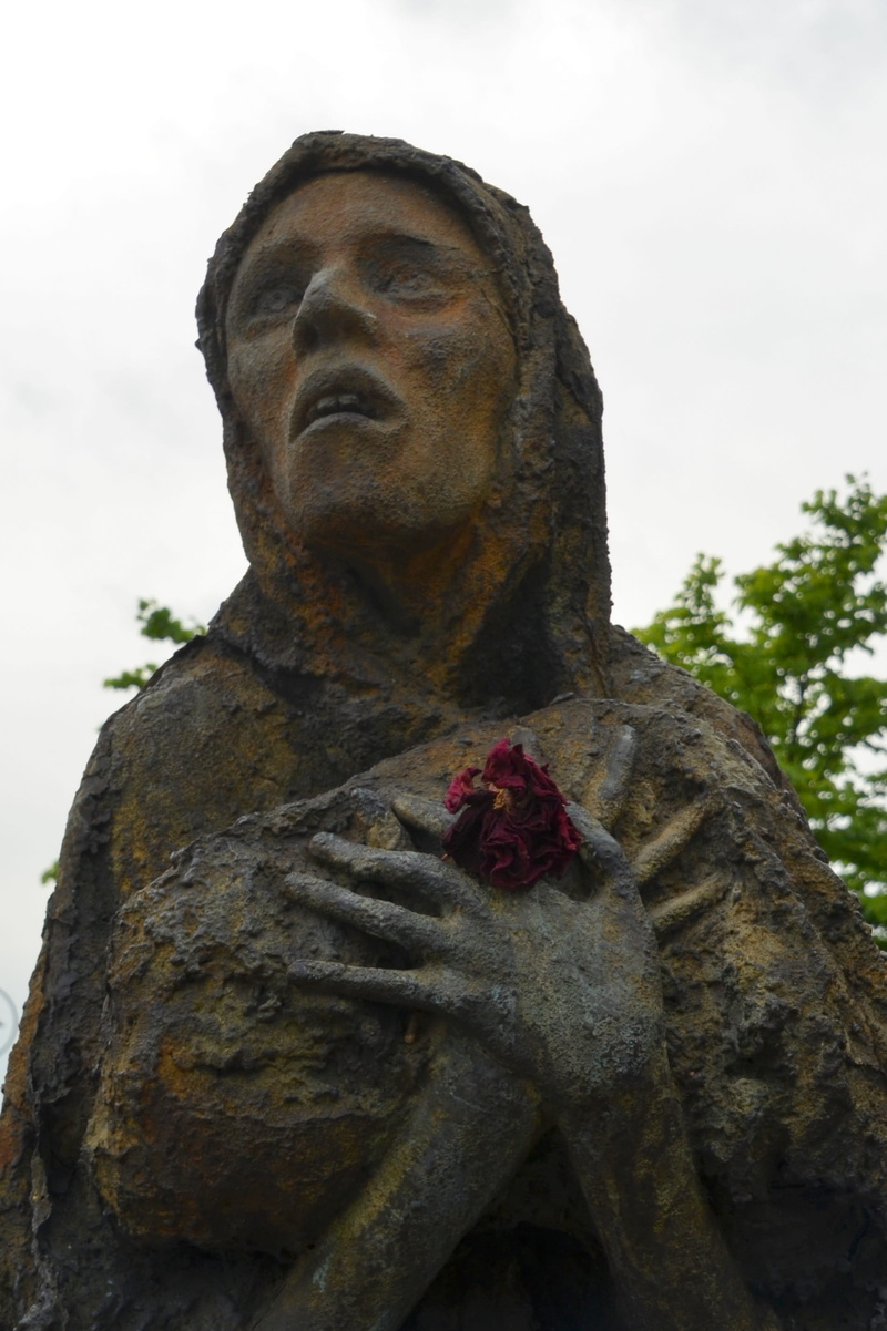 focus on foreground, religion, spirituality, sculpture, sad, male likeness, Suffering, outdoors, human, day, 2K, adult, craft, statue, plant, low angle view